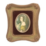 Miniatura policromada de formato oval, representando retrato de jovem dama. Moldura retangular ornada por friso perolado. Verso com o rótulo A Cameo Creation.