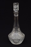 Excepcional garrafa licoreira em grosso cristal europeu com rica lapidação em estrelas na base e na parte frontal, da década de 1920. Medida: A:37 L: 15