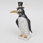 KITSCH - Grande Pinguim em porcelana, da década de 50. Com detalhes pintados na cor dourado (possui marcas do tempo na pintura): cartola e bicos e patas. MED: 34 cm alt x 12 cm comp.