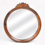 Elegante espelho em madeira nobre bisotado em excelente estado de conservação. Medida: 56 cm de diâmetro. Medida: 62 cm com florão entalhado.