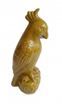 Grupo escultórico em porcelana representado pássaro sobre galho. Medida 28cm.