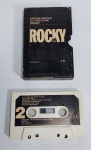Antiga e rara Fita K7 - Trilha sonora original do Filme - ROCKY - 1976 - Made in U.S.A - Medida: 11 cm x 7 cm x 2 cm.