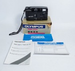 Câmera Fotográfica Olympus Trip 200 - Funcionamento: 2 pilhas AA - Acompanha caixa original, manual de instrução, manual de assistência técnica e certificado de garantia. Foi feito testes iniciais e acendeu uma luz vermelha. Obs: A tampa posterior não está fechando, possui perda das pontinhas das travas, conforme fotos. Medida da caixa: 15 cm x 10 cm x 7 cm.