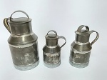 Conjunto de 3 decorativas mini leiteiras em latão galvanizado com tampa e alça. Medida da maior sem à alça: 16 cm de altura x 9 cm de diâmetro - Medida da menor sem à alça:11 cm de altura x 6 cm de diâmetro.