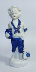 Linda e antiga escultura de jovem camponês em porcelana europeia vitrificada, com detalhes pintados à mão. Medida: 22 cm de altura x 9 cm x 7 cm.