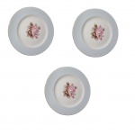 Três pratos em porcelana japonesa decoradas com decalque representando rosas e bordas na cor rosa bebê  e fio dourado sobre fundo branco, marcados na base,  Diam. 27 cm.