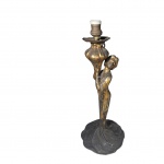 Tocheiro para uma luz em metal patinado de dourado representando dama sustentando flor seu vestido termina em cauda para a base, Alt. 35, Diam. 15 cm.