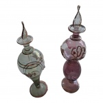 COLECIONISMO - Par de antigos frascos de perfumeiros egípcios, nas cores lilás e  verde decorados com filetes dourado, uma das tampas com a haste interna quebrada, Alt. 18 cm.