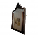 Espelho com moldura em madeira com pinhas laterais de bronze, medalhão central, apresenta leve desgaste na coloração da madeira, 64  x 104 cm.
