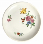 REAL - Gracioso medalhão em porcelana branca esmaltada ricamente adornada com motivo floral em policromia. Possui registro da manufatura no verso. Mede 28cm.