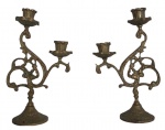 Antigos candelabros em bronze para duas velas adornados com flores e folhas. Desgaste do tempo. Mede 25 cm de altura.