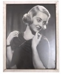 Quadro decorativo com foto reprint da atriz hollywoodiana BETTE DAVIS protegida por moldura de madeira patinada em branco e vidro transparente anti-reflexo.  Mede 33 x 25cm.