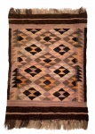 ANOS 70 - Antigo tapete kilim feito a mão adornado com figuras geométricas em policromia e franjas. Necessita higienização. Mede 106cm X 73cm.