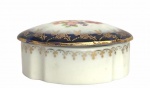 ALEMANHA - Delicado porta joias em porcelana alemã, formato ovalado, adornado com motivo floral em policromia, contorno em azul real com guirlandas em vibrante ouro. Possui registro da manufatura e etiqueta italiana. Acompanha a sua tampa. Mede 8cm.