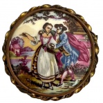 LIMOGES - Antigo broche em pasta de porcelana francesa Limoges adornado com cena galante em policromia e  protegido por moldura em bronze ormolu. Possui registro da manufatura. Mede 5cm de diâmetro.