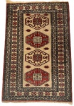 Tapete persa feito a mão, adornado com figuras geométricas e flores sobre fundo vermelho. Desgaste na franja. Mede 1,27 x 81cm.