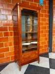 MOBILIÁRIO - Antiga vitrine em madeira nobre marchetada com aplicações de bronze cinzelado, porta em vidro, interior com fundo espelhado com 3 prateleiras e 2 prateiras em vidro. Med. 220x93x62 cm.