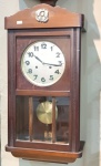 Relógio de parede no mostrador em metal marca Masson, possui chave e pêndulo - 65 x 31cm (não nos re
