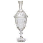 Bomboniere em cristal, no formato de copo alto apoiado em base circular. Bojo facetado em gomos verticais e tampa longilínea. 34 cm.