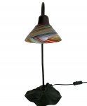 Luminária de mesa para uma lâmpada. Apresenta haste em bronze e cúpula em vidro multicolorido.