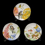 Conjunto com três pratos em louça policromada, apresentando decoração com pássaros e flores. No fundo marca da manufatura. 20 cm.