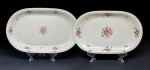 Koenigszelt, Polônia, fabricação entre 1945 e 1954. Duas travessas em porcelana com bordas arredondadas. Decoração floral. 39 x 24 cm, a maior; 28 x 18 cm, a menor. Íntegras, sem bicados ou quebrados.