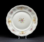 Porzellanfabrik Königszelt A.G. Polônia, fabricação entre 1945 e 1954. Elegante travessa para bolo em fina porcelana esmaltada e vitrificada, decorada com ramagens de flores e borda sinuosa. Diâmetro =  32 cm. Em bom estado de conservação.