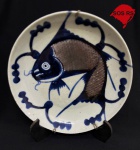 Japão, século XIX. Raro, elegante e mais do que centenário prato em porcelana decorado com peixe (carpa) em azul e escamas em vermelho ferruginoso. Acompanha gancho. Diâmetro = 21 cm. Altura = 3,5 cm. Em ótimo estado de conservação.