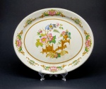Barratt´s of Staffordshire Ltd, Inglaterra, século XX. Elegante travessa em porcelana policromada em tons de rosa, caramelo e verde, modelo dito "oriental vase". Medidas: 29 cm (b) x 2,5 cm (h) x 24 cm (p). Em bom estado geral de conservação.