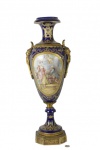 Imponente ânfora em porcelana de Sévres, na cor azul cobalto, com medalhões pintados a mão representando cena romântica, assinado A. Collinet, com profusão de trabalhos em tinta de ouro e suportes em bronze ormolu -med. 68cm