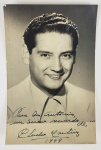 CHUCHO MARTINEZ GIL (1917-1988)  FOTOGRAFIA AUTOGRAFADA COM DEDICATORIA A DOM ANTONIO DATADA DE 1949. 14 CM DE ALTURANOTA: Chucho Martínez Gil (nascido Jesús Bojalil Gil ; 19 de dezembro de 1917, Puebla  22 de maio de 1988) foi um cantor e compositor mexicano .. Seu pai era Felipe Bojalil, de origem libanesa e sua mãe era Carmen Gil de Bojalil. 1 Seus irmãos Alfredo e Felipe Gil também eram músicos reconhecidos. Durante a infância viveu em Misantla e Xalapa , onde frequentou a escola primária e secundária. Mais tarde morou na América Central e do Sul, em Cuba e Porto Rico . Ele também morou por um tempo no Canadá e em diferentes épocas nos Estados Unidos . Iniciou sua carreira musical em 1934, aos dezessete anos, em uma turnê com Gonzalo Curiel. Seus primeiros sucessos foram as valsas Ensoñación e Dos arbolitos , canção que também foi interpretada por diversos cantores fora do México. Outras obras importantes foram: Río cristal , Amanhã você virá , Rosita está tomando banho , Eu vi você chegar , Uma lembrança, Minha Magdalena , El pocito de Nacaquinia , Amor chegou , Esclavo , Pimpollo , Vamos dançar Cha Cha Cha , Terroncito terroncito , Meu coração dói , Cinco letras que choram , Menos que nada , A laranjeira , Eu te seguirei , Já vou embora , Saudades Do Brasil , O escapulário e A flor . Algumas de suas obras foram compostas em conjunto com seus primos Pablo e Carlos Martínez Gil. Chucho Martínez Gil recebeu numerosos prêmios durante sua vida, incluindo o da Sociedade de Autores e Compositores Musicais (SACM), que lhe concedeu a Medalha Agustín Lara ; O Diploma de Honra concedido pelo Lions Clube de Monterrey e pela cidade de Misantla concedeu-lhe a cidadania honorária em maio de 1975.