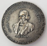 CENTENÁRIO DA INDEPENDENCIA DO BRASIL - MEDALHA ESPESSURADA A PRATA ACONDICIONADA EM SEU ESTOJO ORIGINAL COMEMORATIVA DO CENTENÁRIO DA INDEPENDENCIA DO BRASIL EM 1922. MEDALHA CUNHADA PARA EXPOSIÇÃO INTERNACIONAL DO CENTENÁRIO DA INDEPENDENCIA REALIZADA NA CIDADE DO RIO DE JANEIRO DE 1922 A 1923. ACONDICIONADA EM SEU ESTOJO ORIGINAL CONTENDO INSCRIÇÕES BRINDE DO ARTISTA ADR.HUYBERS BRUXELAS. A MEDALHA TEM NO ANVERSO CENA DO GRITO DO IPIRANGA COM INSCRIÇÃO INDEPENDÊNCIA OU MORTE. NO VERSO HERMA DE JOSÉ BONIFÁCIO E INSCRIÇÕES GLORIA AOS FUNDADORES DA INDEPENDENCIA, JOSÉ BONIFÁCIO E 1822 7 DE SETEMBRO 1922. TAMBEM AS INSCRIÇOES HOMENAGEM DO ARTISTA A SEBASTIÃO VIEIRA DE ALMEIDA. 53 MM DE DIAMETRONOTA: A Exposição Internacional comemorativa do Centenário da Independência do Brasil (1822-1922) foi inaugurada no dia 7 de setembro de 1922 e se prolongou até o dia 24 de julho do ano seguinte. Realizada no mesmo ano de outros eventos relevantes para a história brasileira, como a Semana de Arte Moderna, a fundação do Partido Comunista Brasileiro (PCB) e a Revolta do Forte de Copacabana, a Exposição do Centenário vem despertando crescente interesse da historiografia preocupada com o tema da identidade nacional na década de 1920. A celebração do Centenário da Independência foi reclamada com bastante antecedência. Um exemplo relevante dessa vigilância comemorativa foi dado pela Revista do Brasil, fundada em janeiro de 1916. Logo em seu primeiro número, a revista, com razoável antecedência de seis anos, pregava a necessidade de se comemorar festivamente esse primeiro marco glorioso da existência nacional. A realização de uma Exposição Universal no Rio de Janeiro, então capital federal, destacou-se como a mais ambiciosa das atividades comemorativas então programadas. Desde a primeira exposição internacional em Londres (1851), cujo símbolo foi o Palácio de Cristal, as chamadas vitrines do progresso sempre apresentaram alguns aspectos em comum, entre os quais se destacavam, entre outros, as motivações comerciais, o afluxo de divisas e turistas, o impacto sobre a infraestrutura urbana, e a difusão de valores e de padrões de conduta. O mais importante, e ainda hoje é assim, era a afirmação do prestígio nacional, representado pelos pavilhões de cada país que constituíam a ossatura das exposições.A participação brasileira nessas vitrines do progresso se iniciou de maneira muito discreta na Exposição Internacional de Londres de 1862. Antes disso, em 1861, a Sociedade Auxiliadora da Indústria Nacional (SAIN) havia organizado uma Exposição Nacional no prédio da Escola Politécnica, no largo de São Francisco, no Rio de Janeiro. De maior porte foi a Exposição Nacional de 1908, em comemoração do Centenário da Abertura dos Portos brasileiros ao comércio internacional. Tendo como objetivo a preparação da participação brasileira na Exposição Internacional de Bruxelas (1910), o evento de 1908 visava igualmente a apresentar a nova capital saneada e urbanizada a partir das grandes reformas realizadas durante a gestão do prefeito Pereira Passos. Em junho de 1920, Ralph de Cobham, representante de um grupo de capitalistas estrangeiros no Brasil, sugeriu ao Ministério da Agricultura, Indústria e Comércio a realização de uma exposição internacional de comércio e indústria para a comemoração do Centenário da Independência. Coube ao senador Paulo de Frontin, um mês depois, propor ao Congresso Nacional a emissão de cem mil contos para financiar o evento, provocando intenso debate sobre a disponibilidade de tão vultosos recursos em conjuntura de grave crise financeira. Pelo Decreto nº 4.175, de 11 de novembro de 1920, foi enfim determinada a realização da exposição dentro do programa de comemorações do Centenário. A regulamentação oficial das atividades comemorativas só ocorreu quase um ano depois, com o Decreto nº 15.066, de 24 de outubro de 1921, que previa, além da exposição, a realização de numerosas conferências e a publicação de dicionários, mapas e livros comemorativos.Coube ao Ministério da Agricultura, Indústria e Comércio, então chefiado pelo engenheiro João Pires do Rio, a organização da exposição, que deveria compreender as principais modalidades do trabalho no Brasil, relacionadas à lavoura, à pecuária, à pesca, à indústria extrativa e fabril, ao transporte marítimo, fluvial, terrestre e aéreo, aos serviços de comunicação telegráficos e postais, ao comércio, às ciências e às belas artes. Era prevista ainda a concessão de uma área contígua aos pavilhões nacionais para que governos ou industriais estrangeiros pudessem construir, por conta própria, pavilhões destinados à exibição de seus produtos.Para cumprir o objetivo de ser a expressão da vida econômica e social do Brasil em 1922, a parte nacional da exposição se comporia de 25 seções representativas das principais atividades do país: educação e ensino; instrumentos e processos gerais das letras, das ciências e das artes; material e processos gerais da mecânica; eletricidade; engenharia civil e meios de transporte; agricultura; horticultura e arboricultura; florestas e colheitas; indústria alimentar; indústrias extrativas de origem mineral e metalurgia; decoração e mobiliário dos edifícios públicos e das habitações; fios, tecidos e vestuários; indústria química; indústrias diversas; economia social; higiene e assistência; ensino prático, instituições econômicas e trabalho manual da mulher; comércio; economia geral; estatística; forças de terra e esportes. A seleção dos expositores seria feita por comissões julgadoras encarregadas de dar parecer sobre a escolha conveniente dos produtos expostos, bem como de avaliar a qualidade e a quantidade daqueles que deveriam ser admitidos na exposição. Estavam ainda previstas atividades paralelas, como a exibição de filmes sobre assuntos que se relacionassem com a produção nacional e as riquezas naturais do país, bem como a realização de conferências sobre temas econômicos.As obras de preparação da área da exposição mobilizaram a população carioca. A demolição do morro do Castelo, berço da cidade, para dar lugar à construção dos pavilhões e palácios nacionais e estrangeiros, provocou aceso debate entre os que consideravam o arrasamento um imperativo da modernidade, e aqueles que viam o desaparecimento da colina sagrada como um verdadeiro sacrilégio. Os gastos excessivos com um empreendimento tão custoso, especialmente em uma época de dificuldades financeiras, bem como a demora na construção dos prédios, muitos só concluídos após a inauguração da exposição, provocaram, de parte a parte, ataques contundentes e defesas inflamadas. De qualquer modo, é importante lembrar que a edificação de um espaço especialmente criado para a exposição tinha o intuito de revelar a capacidade do anfitrião de realizar empreendimentos excepcionais. De modo semelhante, para a Exposição de Saint Louis (EUA), em 1904, lagos foram aterrados e rios desviados.A Exposição do Centenário foi festivamente inaugurada na data magna, 7 de setembro de 1922. A seção nacional localizou-se na Misericórdia, entre o antigo Arsenal de Guerra e o novo mercado, estendendo-se em parte da área conquistada ao mar com o desmonte do morro do Castelo. Nesse local, concentraram-se oito pavilhões: do Comércio, Higiene e Festas; das Pequenas Indústrias; da Viação e Agricultura; da Caça e Pesca; da Administração; de Estatística, aos quais se somavam os palácios das Indústrias e dos Estados.Na avenida das Nações, que se estendia do antigo Arsenal até o palácio Monroe  onde funcionava o bureau de informações , alinharam-se os palácios de honra das representações estrangeiras. Treze países aí se fizeram representar: da América, Estados Unidos, Argentina e México; da Europa, Inglaterra, França, Itália, Portugal, Dinamarca, Suécia, Tchecoslováquia, Bélgica e Noruega; da Ásia, o Japão. Apenas quatro desses prédios resistiram ao tempo e à especulação imobiliária: o pavilhão da Administração (Museu da Imagem e do Som); o palácio da França (Academia Brasileira de Letras); o palácio das Indústrias (Museu Histórico Nacional); e o pavilhão de Estatística (órgão do Ministério da Saúde).Passadas as festas de inauguração, a exposição ficou aberta aos visitantes que, oriundos da capital e dos outros estados, acorreram em massa aos palácios e pavilhões, bem como ao alegre e movimentado parque de diversões. Os registros apontam para o mês de fevereiro de 1923, considerado fraco pelo calor que assolava a cidade, uma frequência de 175 mil visitantes, com piques de até 14 mil pessoas em um só dia.Primeira exposição a se realizar após a Grande Guerra, o grande desafio da Exposição do Centenário foi o de traduzir a vontade de renovação que então mobilizava o mundo. Se a ênfase nos mostruários dos palácios nacionais ainda recaiu sobre as riquezas naturais do país, o que deveria ser ressaltado, e efetivamente o foi, era a possibilidade de exploração desses recursos naturais. No século XX, quem dava as cartas era a ciência, expressa na confiabilidade dos dados estatísticos, nas maravilhas da química, nas luzes da eletricidade, na magia do rádio. A primeira transmissão de rádio no Brasil ocorreu justamente durante a inauguração da Exposição do Centenário, com o discurso do presidente Epitácio Pessoa.