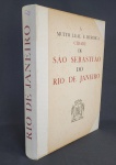 A MUITO HEROICA CIDADE DE SÃO SEBASTIÃO DO RIO DE JANEIRO - PARIS  MARCEL MOUILLOT, 1965, 1ª EDIÇÃO ORIGINAL. TEXTOS E SELEÇÃO DE DOCUMENTOS POR GILBERTO FERREZ. EX LIBRES DA BIBLIOTECA DO  ESCRITOR ARNALDO MACHADO. TIRAGEM DE 1.000 EXEMPLARES, NUMERADOS DE 1 A 1.000 E 100 EXEMPLARES, FORA DO COMÉRCIO, NUMERADOS EM ALGARISMOS ROMANOS, RESERVADOS À COMISSÃO ORGANIZADORA E AOS COLABORADORES, SENDO QUE AS MATRIZES QUE SERVIRAM PARA A ILUSTRAÇÃO FORAM DESTRUÍDAS. ESTE É O EXEMPLAR Nº 973. QUATRO SÉCULOS DE EXPANSÃO E EVOLUÇÃO. INICIATIVA DE RAYMUNDO DE CASTRO MAYA EM COMEMORAÇÃO DO IVº CENTENÁRIO DA FUNDAÇÃO DA CIDADE. TEXTOS E ORGANIZAÇÃO DE GILBERTO FERREZ. EXECUTADO EM PARIS SOB A DIREÇÃO DE MARCEL MOUILLOT. EDITADO POR RAYMUNDO DE CASTRO MAYA, CANDIDO GUINLE DE PAULA MACHADO, FERNANDO MACHADO PORTELLA, BANCO BOAVISTA SA 1965. ENCADERNAÇÃO DO EDITOR EM PERCALINA COM GRAVAÇÃO A OURO NA CAPA ANTERIOR. ILUSTRADO COM UMA VASTA E INTERESSANTE SELEÇÃO DE AGUARELAS, GRAVURAS, MAPAS, DOCUMENTOS E FOTOS, TANTO A CORES, COMO A PRETO E BRANCO. IMPRESSO SOBRE PAPEL MUITO INCORPADO E DE QUALIDADE PURO LINHO FILIGRANADO COM AS ARMAS DA CIDADE DO RIO DE JANEIRO. O TEXTO FOI IMPRESSO NO MANUAL ANTERIOR. AS REPRODUÇÕES EM FOTOTIPIA; A CORES COLORIDAS À MÃO PELO PROCESSO AU POCHOIR NO ATELIER DART LIBIS E NOS ÉTABLISSEMENTS NERVET.  ICONOGRAFIA DE QUALIDADE QUE DOCUMENTA QUATRO SÉCULOS DE HISTÓRIA DO RIO DE JANEIRO, ATRAVÉS DE UMA VASTA E INTERESSANTE SELEÇÃO DE AGUARELAS, GRAVURAS, MAPAS, DOCUMENTOS E FOTOS. CONTÉM UM ÍNDICE DAS ILUSTRAÇÕES NAS ÚLTIMAS PÁGINAS NÃO NUMERADAS. NOTA: À época do estabelecimento do sistema de Capitanias Hereditárias no Brasil, a região da baía do Rio de Janeiro (mais tarde, renomeada para baía de Guanabara) foi entregue a Martim Afonso de Souza e compunha o 1º lote ou a porção setentrional da Capitania de São Vicente, cujo território ia da atual cidade de Macaé até a atual cidade de Caraguatatuba, e era separada do 2º lote ou da porção meridional da Capitania de São Vicente pela Capitania de Santo Amaro (de Caraguatatuba a Bertioga). A região norte do atual Estado do Rio de Janeiro compunha a Capitania de São Tomé ou Capitania da Paraíba do Sul, e foi entregue inicialmente a Pero de Góis.No entanto, as primeiras tentativas de colonização portuguesa tanto na parte setentrional de São Vicente quanto em São Tomé acabaram fracassando, em virtude da hostilidade dos tamoios (os índios tupinambás da Guanabara) e dos goitacás (índios tapuias da região de Campos). Em 1555, os tamoios fizeram uma aliança com a coroa francesa e autorizaram que os franceses estabelecessem uma colônia na margem ocidental da baía de Guanabara, sob o comando do almirante e cavaleiro templário Nicolas Durand de Villegagnon. Essa colônia recebeu o nome de "França Antártica" e tinha como capital Henriville (cidade de Henrique), localizada no atual bairro do Flamengo na Zona Sul da capital fluminense.Visando a evitar esta ocupação e a assegurar a posse do território para a Coroa Portuguesa, foi fundada a cidade de São Sebastião do Rio de Janeiro, em 1.º de março de 1565, por Estácio de Sá, no morro do Cara de Cão, na atual bairro da Urca. Estácio de Sá pode ser considerado o primeiro governador-geral do Rio de Janeiro, no período colonial. Entre o grupo de fundadores, incluía-se também Dom Antônio de Mariz e o Padre José de Anchieta, que participou dos preparativos para a tomada do Rio de Janeiro e mais tarde da organização das primeiras vilas no recôncavo da Guanabara e na sua margem oriental, como, por exemplo, a vila de São Lourenço dos Índios do Rio de Janeiro (atual cidade de Niterói). Como a região foi recuperada por uma conquista bélica patrocinada pela coroa, a sua propriedade foi revertida para a família real portuguesa (deixando de ser, portanto, uma capitânia hereditária da família Souza). Em decorrência desse fato, a Capitânia de São Vicente Setentrional passou a chamar-se Capitania Real do Rio de Janeiro, tornando-se a segunda capitânia real da América Portuguesa (após a da Bahia de Todos os Santos, em 1548). Diferentemente das capitanias donatárias, as capitanias reais possuíam administradores indicados pela coroa e não proprietários.Mais tarde, em 1621, por iniciativa do governador Martim Correia de Sá, que concedeu sesmarias na região de Campos dos Goytacazes, a antiga Capitânia de São Tomé foi povoada e por fim anexada a do Rio de Janeiro, dando a ela uma forma muito parecida a do atual Estado do Rio de Janeiro. A Carta Régia de 30 de junho de 1642, passada pela Chancelaria de D. João IV, outorgou o título de "a muy heróica e leal cidade de São Sebastião do Rio de Janeiro", conferindo aos cidadãos do Rio o título de "homens bons do Porto", o que lhe assegurava os mesmos direitos e privilégios dos cidadãos de Lisboa e do Porto. Em 1763, a cidade do Rio de Janeiro tornou-se a sede do Vice-reino do Brasil e a capital da colônia. Com a transferência da corte portuguesa para o Brasil, em 1808, na época da tomada da Península Ibérica por Napoleão Bonaparte, a região foi muito beneficiada com reformas urbanas para abrigar a Corte portuguesa. Dentro das mudanças promovidas, destacam-se: a transferência de órgãos de administração pública e justiça, a criação de novas igrejas, hospitais, quartéis, fundação do primeiro banco do país  o Banco do Brasil  e a Imprensa Régia, com a Gazeta do Rio de Janeiro. Nos anos seguintes também surgiram o Jardim Botânico, a Biblioteca Real (hoje Biblioteca Nacional) e a Academia Real Militar, antecessora da atual Academia Militar das Agulhas Negras.