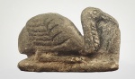 FRAGMENTO DE ESCULTURA VOTIVA COM FEITIO DE THOTH  - AVE SAGRADA (IBIS) UMA DAS REPRESENTAÇÕES DE THOTH. CONSTRUIDA EM PASTA DE PEDRA (GRÃOS DE QUARTZO EM PÓ FINO FUNDIDOS COM PEQUENAS QUANTIDADES DE ÁLCALI E/OU CAL POR MEIO DE AQUECIMENTO PARCIAL) EPOCA SAITA, ESCAVADA EM MENFIS . THOTH ERA O DEUS EGÍPCIO DA ESCRITA, DA SABEDORIA E DA MAGIA. ELE ESTAVA ASSOCIADO À ORDEM E À JUSTIÇA E ERA CONSELHEIRO E MEDIADOR DOS DEUSES. PATRONO DOS ESCRIBAS, SUA CONTRAPARTE FEMININA ERA SESHAT, DEUSA DA ESCRITA E GUARDIÃ DOS LIVROS, THOTH CRIOU A LINGUAGEM E SESHAT DEU SUAS PALAVRAS AO POVO.SEC. VII. AC. 7 CM DE COMPRIMENTO. NOTA: Os deuses egípcios estavam sempre em conflito e o papel de Thoth como mediador e solucionador de problemas era frequentemente solicitado. Quando Rá amaldiçoou sua filha Nut, proibindo-a de dar à luz em qualquer dia do ano, ela veio a Thoth em busca de ajuda. O velho e sábio Thoth superou a maldição apostando com o Deus da Lua (Khonsu) por um pouco de sua luz. Ele ganhou 1/72 da luz da lua. O suficiente para cinco dias extras no ano, permitindo que Nut tenha seus cinco filhos (Osíris, Ísis, Geb, Néftis e Hórus) e ampliando o calendário anual de 360 para 365 dias.Novamente, quando Set assassinou seu irmão Osíris, foi Thoth quem ajudou sua esposa Ísis a realizar o ritual para trazê-lo de volta à vida e deu-lhe as palavras mágicas para que Osíris pudesse gerar Hórus. Mais tarde, ele usou sua sabedoria e magia para apoiar Hórus nas guerras em curso com Set.Mais uma vez, quando Tefnut, a Deusa da chuva e da umidade  essencial para manter a vida no ambiente desértico do Egito  se afastou de seu pai Rá e fugiu para a Núbia. Rá enviou Thoth com Shu (mensageiro dos deuses e marido de Tefnut) disfarçados de babuínos para persuadi-la a voltar para casa. Eles tiveram sucesso em sua busca e retornaram com grande alegria na terra do Egito. Thoth também ajudou Osíris e Anúbis no Salão da Verdade, registrando o resultado da pesagem do coração contra a pena da verdade. Decidir se uma pessoa pode ou não entrar na vida após a morte. Joshua J. Marks escreve: Sua casa na vida após a morte, conhecida como Mansão de Thoth, fornecia um lugar seguro para descansar e receber feitiços para ajudá-los contra os demônios que os impediriam de chegar ao paraíso. Sua magia também foi fundamental para a revitalização da alma que trouxe os mortos de volta à vida no submundo. Há evidências de que Thoth é uma das primeiras divindades conhecidas e que sua adoração remonta ao período pré-dinástico (6.000-3.150 aC). Seu culto também foi aceito e venerado pelas famílias reais posteriores e no Segundo Período Intermediário o nome Tutmés, que significa Nascido de Thoth, aparece três vezes na Cronologia dos Faraós.Na Colina Thoth, o ponto norte da Necrópole de Tebas, fica o templo mais antigo conhecido em Tebas. Aqui foram escavadas três estátuas de babuínos e fragmentos inscritos com o nome do faraó Mentuhotep II (2055-2004 a.C.).Nas escavações em andamento no templo funerário de Amemhotep III (1390-1352 aC), foram encontradas duas grandes estátuas de Thoth como um babuíno. Pensa-se que estes podem ter feito parte de uma avenida de babuínos que conduz ao templo, semelhante em estilo à avenida de esfinges que vai de Luxor a Karnak. Este Faraó também encomendou as duas estátuas de babuínos de 30 toneladas em Hermópolis.No entanto, a popularidade de Thoth estendeu-se muito além das classes dominantes. Seu centro de culto em Hermópolis atraiu um grande número de peregrinos. Milhares de íbis e babuínos mumificados, usados como oferendas votivas em dias de festa, foram encontrados perto daqui e também em Saqqara. Estátuas de pedra do tipo encontrado no Museu Hunt também teriam sido oferecidas por funcionários e outros indivíduos ricos.Imagens de Thoth em ambas as suas manifestações são encontradas nos túmulos dos sacerdotes dos faraós e nos da população em geral. Amuletos de Thoth como um íbis, e mais frequentemente como um babuíno, foram encontrados em diferentes períodos da história do Egito. Pensa-se que estes foram usados por escribas.