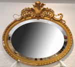 Importante e antigo espelho oval em cristal bisotê com moldura em madeira e apliques em gesso folhea