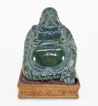 Antiga escultura chinesa representando monge HOTEI (também chamado de Buda Gordo ou Buda da Fortuna), esculpida em bloco de Jade na cor verde espinafre. Base em madeira decorada com gregas.  Med. 12 x 09 x 07 cm.