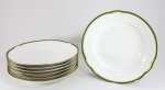 LIMOGES - Lote com 7 pratos fundos antigos em porcelana francesa, bordas decorados com friso verde e dourado. Folhagens moldadas no entorno. Todos com pequenas perdas. Med. 25 cm.