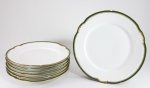 LIMOGES - Lote com 7 pratos rasos antigos em porcelana francesa, bordas decorados com friso verde e dourado. Folhagens moldadas no entorno. Todos com pequenas perdas. Med. 24 cm.