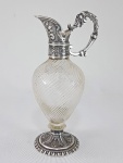 Antiga azeiteira em Prata cinzelada, alça decorada com folhas de Acanto e Máscara, bojo em cristal decorado com caneluras torcidas, possivelmente Baccarat. Base decorada com Palmas. Sem contraste visível. Europa, Séc.XIX. Med. 19 cm.