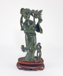 CHINA, DINASTIA QING - SÉC.XIX - Elegante escultura em JADE verde espinafre, representando Cortesã com flores. Med. 21 cm. Base em madeira. Medida total: 24 cm.