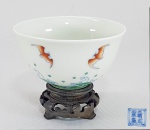 CHINA, DINASTIA QING, período KANGXI (1662-1722) - Delicado bowl para chá em fina porcelana chinesa azul e branca, esmaltes verdes e rouge de fer, adornado com delicados Morcegos e ondas na base. Marca Cheng Hua honorífica no fundo. Med. 7.5 x 3.5 cm.