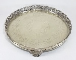 BRASIL, Séc.XIX/XX - Antiga salva em metal branco, galeria recortada com rendado, fenestrada e decorada com flores. Fundo cinzelado e pés em volutas. Med. 32 cm. Peso:950 gramas.