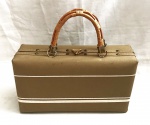 Elegante e estilosa bolsa no estilo maleta no tom bege com detalhe de alça em palha e metal dourado.