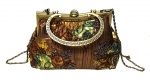 Belíssima bolsa em tecido possivelmente europeia no tom ouro velho decorada por floral revestido em canutilho com armação e alça em metal acobreado ornado por detalhes em relevos.