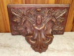 Peanha antiga em madeira de lei ricamente esculpida ao estilo barroco tendo como figura central  dor