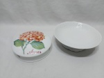 Lote de caixa redonda em porcelana com tampa floral e fruteira redonda com pé em porcelana branca. Medindo a fruteira 19,5cm x 6cm de altura.