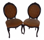 Par de cadeiras medalhão em madeira entalhada com assento estofado e encosto em capitonê - alt. 99cm (total). Apresentam pequenas perdas no encosto