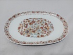 Travessa oval rasa média em porcelana real com borda e centro floral. Medindo 32,5cm x 21,5cm.