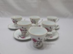 Jogo de 6 xícaras de café com 5 pires em porcelana Schmidt floral com friso ouro. Medindo a xícara 6,5cm x 6,5cm de altura. Desgaste na douração.