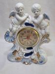Lindo relógio de mesa à quartz com moldura em porcelana, na forma de anjos. Medindo 20cm x 25cm de altura.